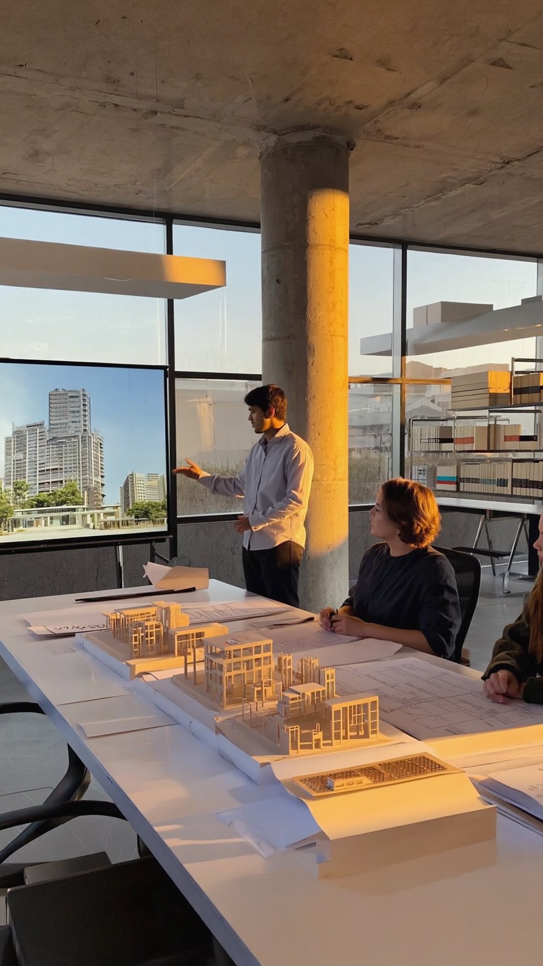 Architect presenting building models and project plans to a team